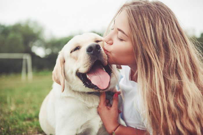 mujer besa a un perro