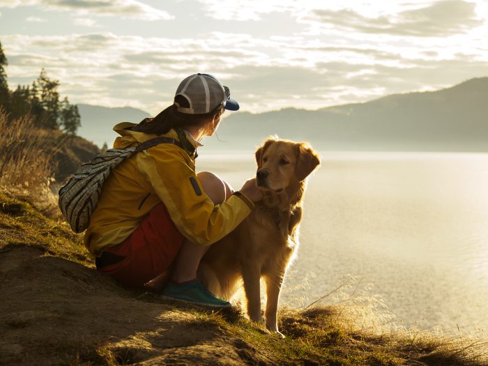 mujer con perro en un lago